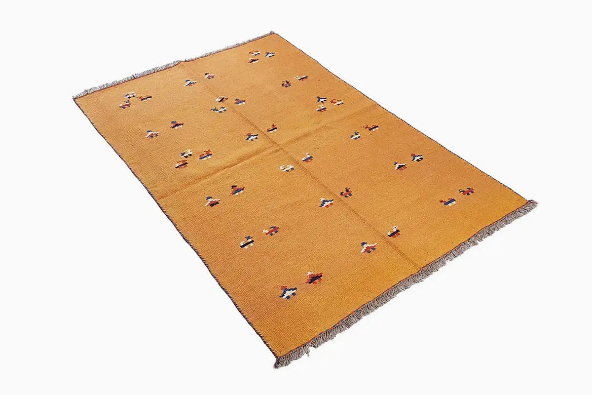 Ochre-brown kilim rug with colorful ornaments arranged diagonally, with fringes