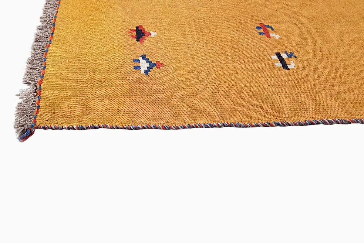 Kilim rug border in ochre brown with colorful patterns and frayed edges