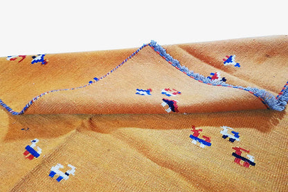 Kilim rug with a visible woven texture, colorful ornaments, and a folded section