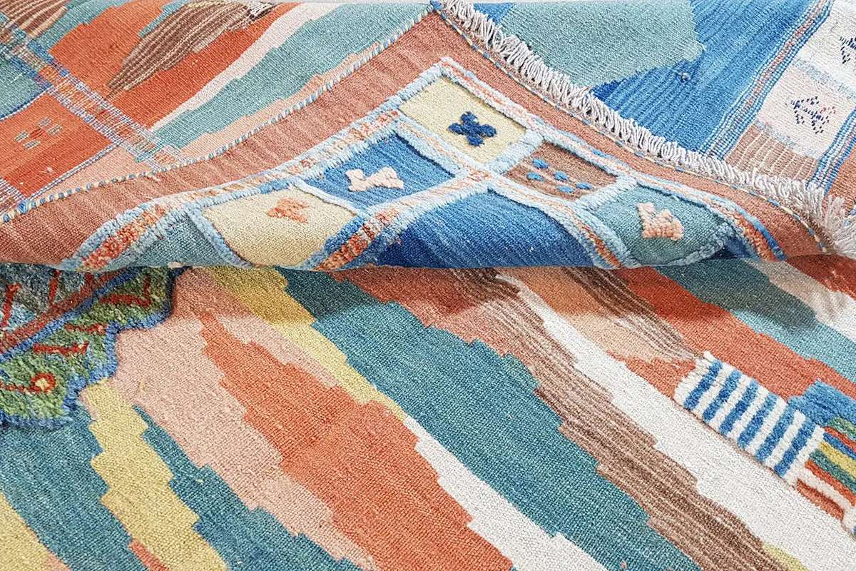 Close-up: kilim rug with geometric stripes in pastel tones and fringes