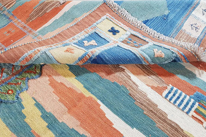 Close-up: kilim rug with geometric stripes in pastel tones and fringes