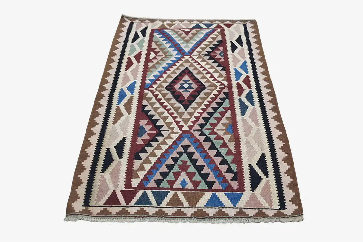 Kilim rug with a central diamond motif and multicolored border trim