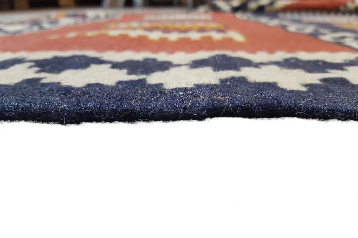 Kilim rug edge with short fringes, color blocks in dark blue and rust orange