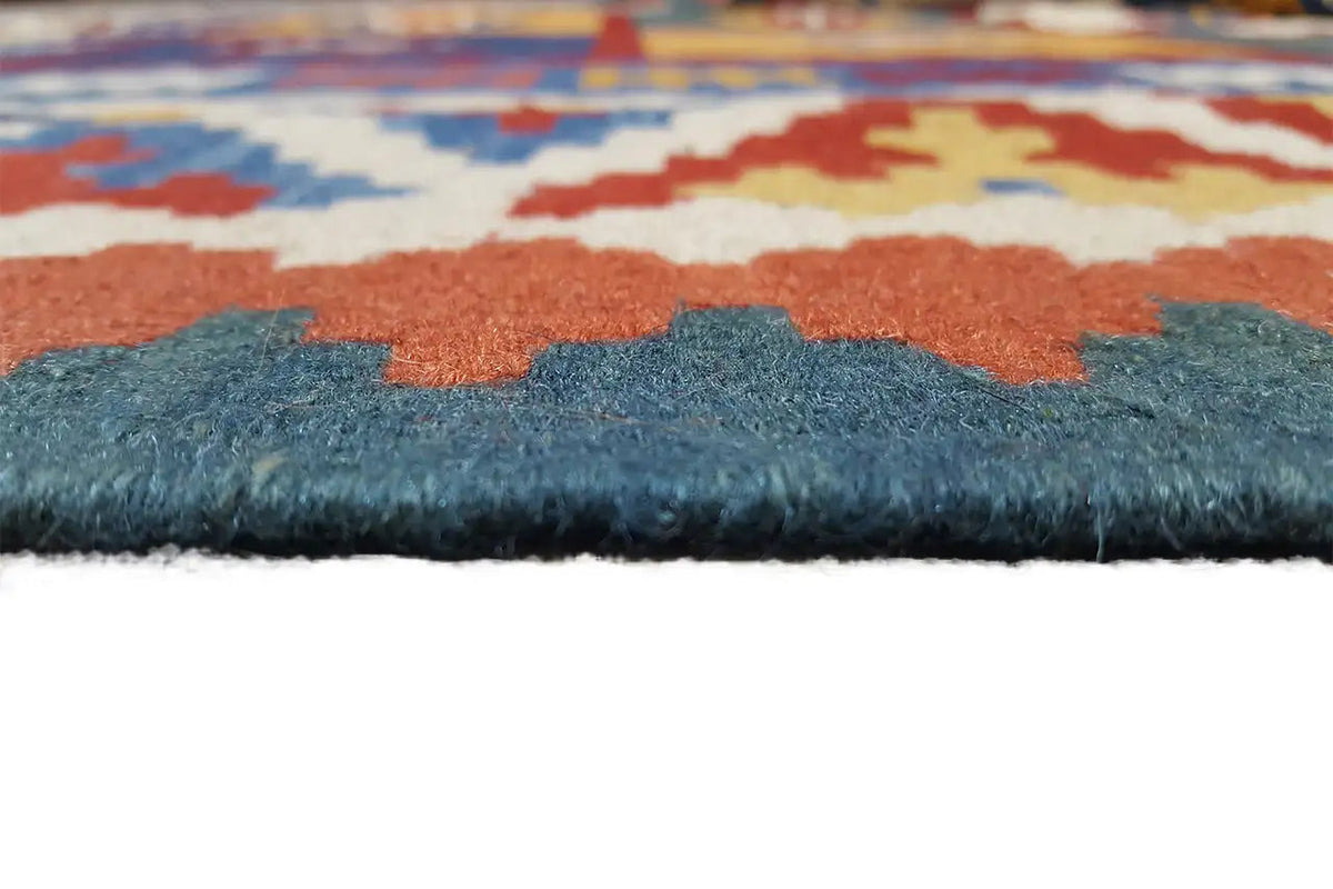 Kilim rug edge view with short pile, blue and orange patterned areas