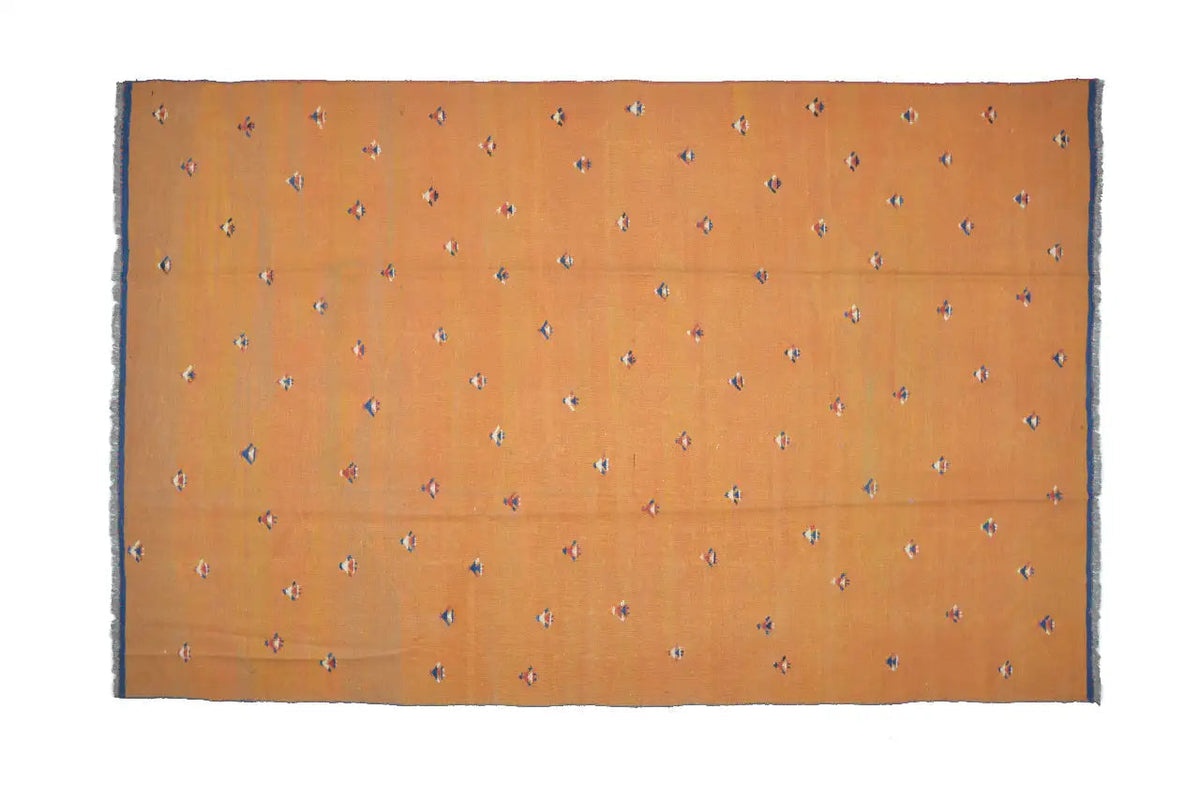Rectangular Oriental rug, warm brown-orange with small colorful patterns and a dark border.