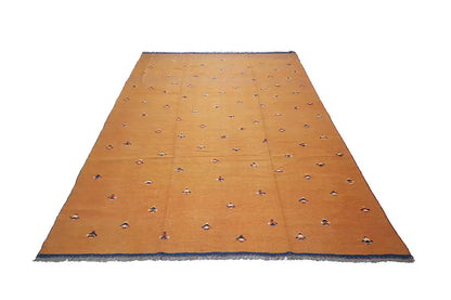 Oriental rug in warm brown-orange with small colorful motifs and a wide blue border.