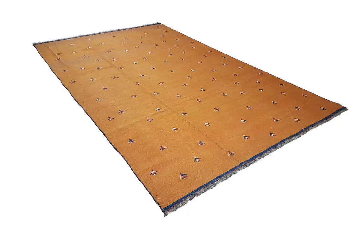 Oriental rug in warm brown-orange with a small, colorful pattern and blue edging.