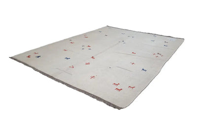 Kelim rug in light beige with a central pattern of red and blue animal figures, folded diagonally