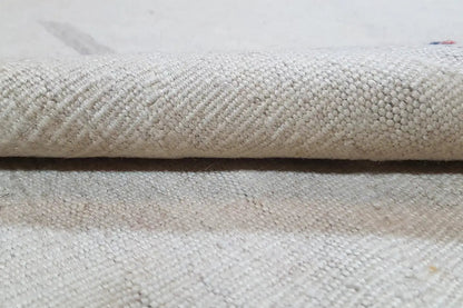 Close-up of a light beige kilim rug: woven texture and edge finish