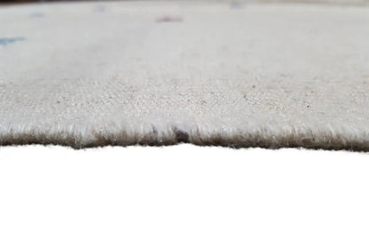 Close-up of the edge of a light beige kilim: short fringe and fine woven texture