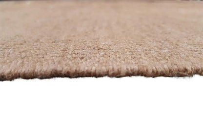 Close-up: uniform beige fabric pile texture with a short frayed edge
