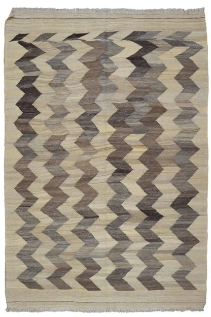 Kilim rug with a zigzag pattern, light beige background, taupe chevrons, and fringes.