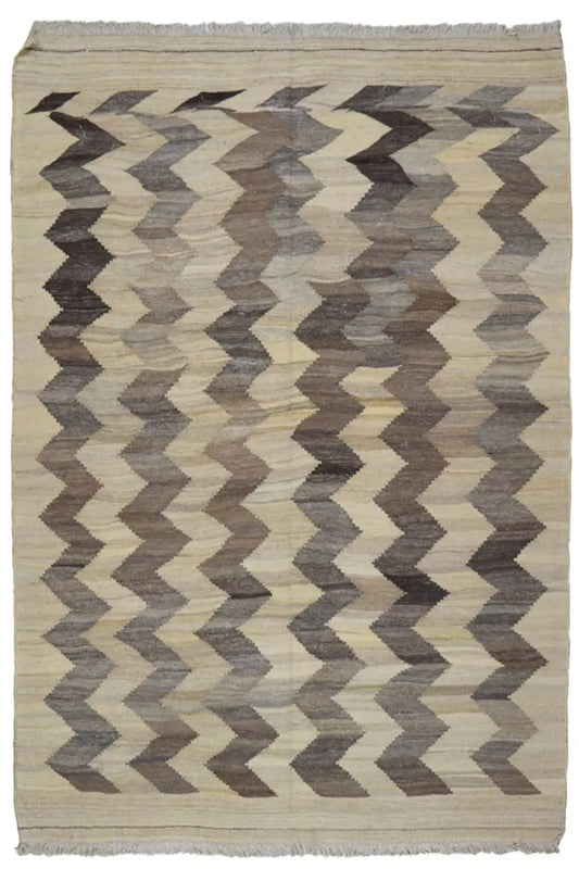 Kilim rug with a zigzag pattern, light beige background, taupe chevrons, and fringes.
