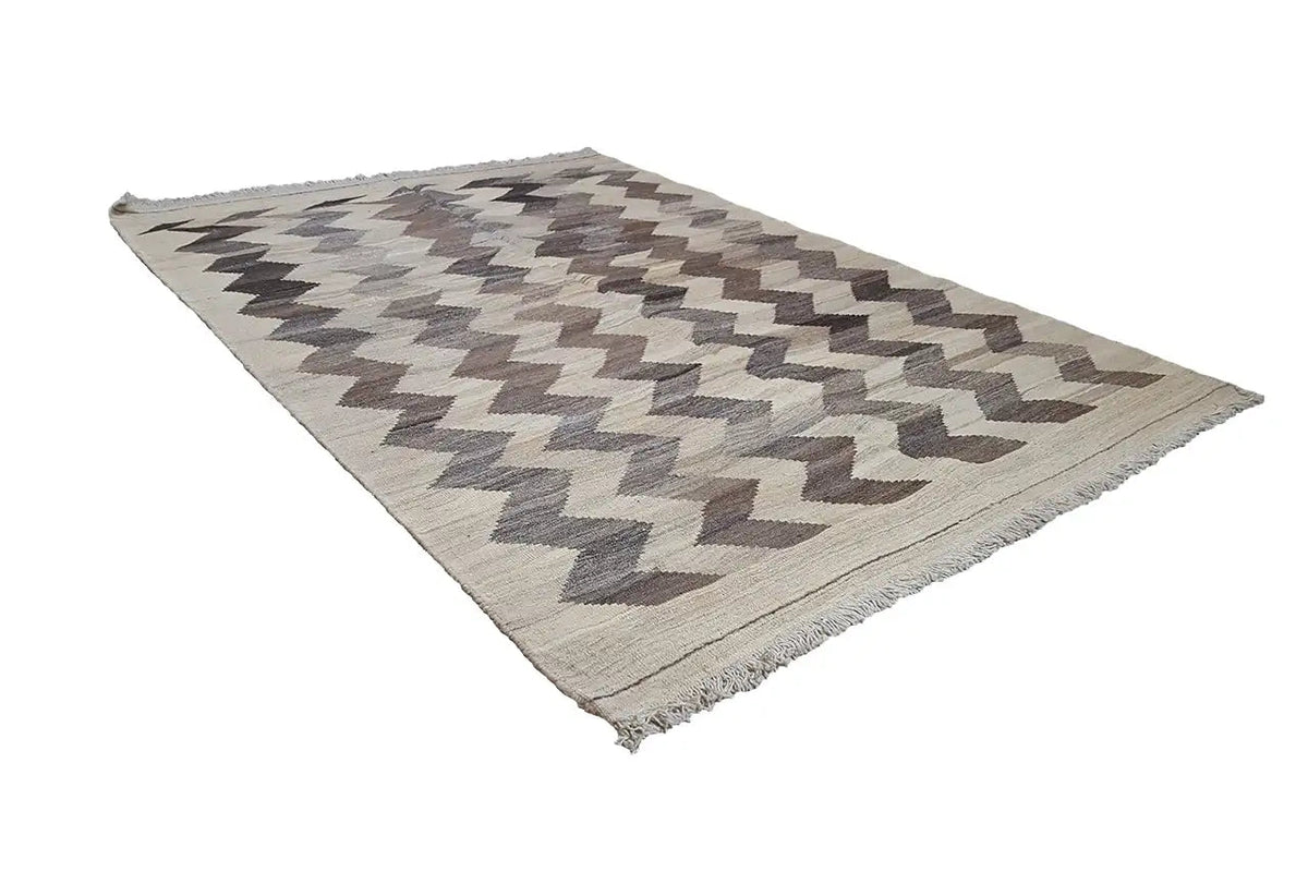 Kilim rug with zigzag stripes, light beige base, dark gray-brown, fringed all around.