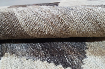 Kilim rug close-up: woven texture, light beige fibers, gray-brown zigzag.