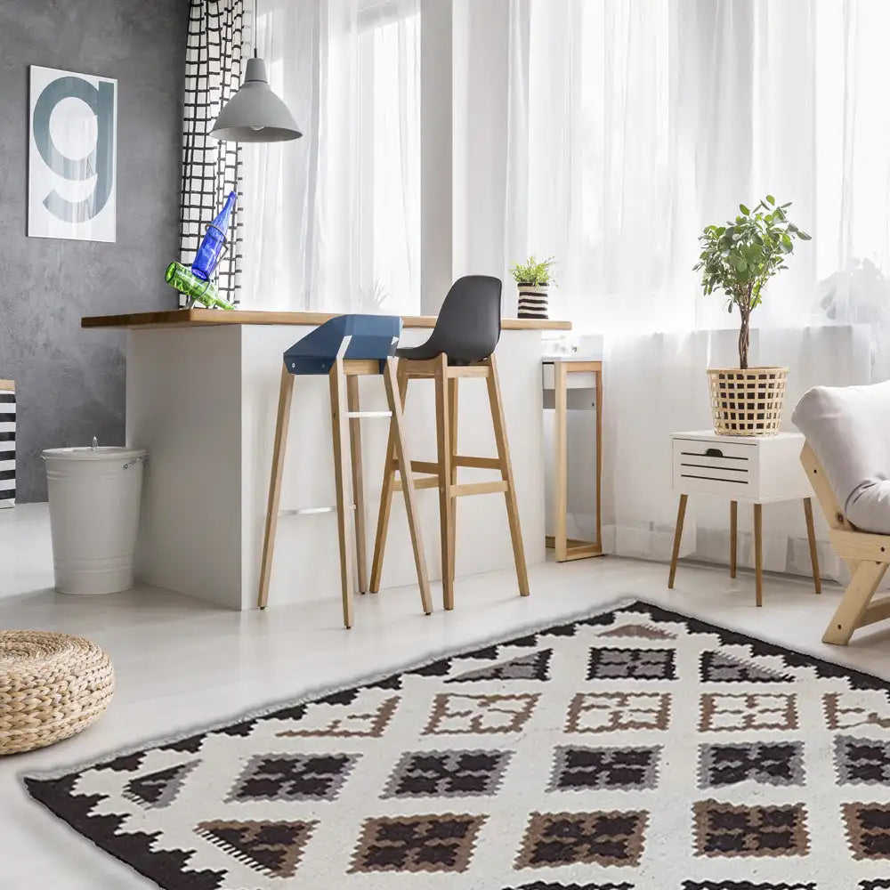 Kilim rug with diamond patterns in cream, black, and brown tones on the floor