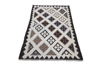 Kilim rug with a geometric pattern in cream, black, and brown tones