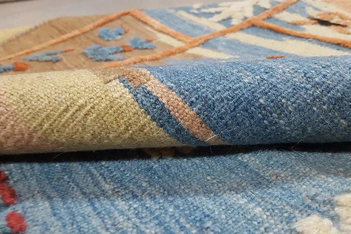 Close-up edge: multicolored patterns on a light background, twisted carpet pile
