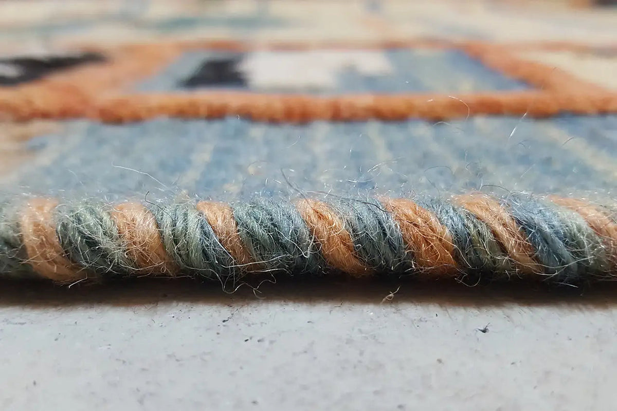 Close-up of fringe and rug edge in blue and brown, with visible fibers