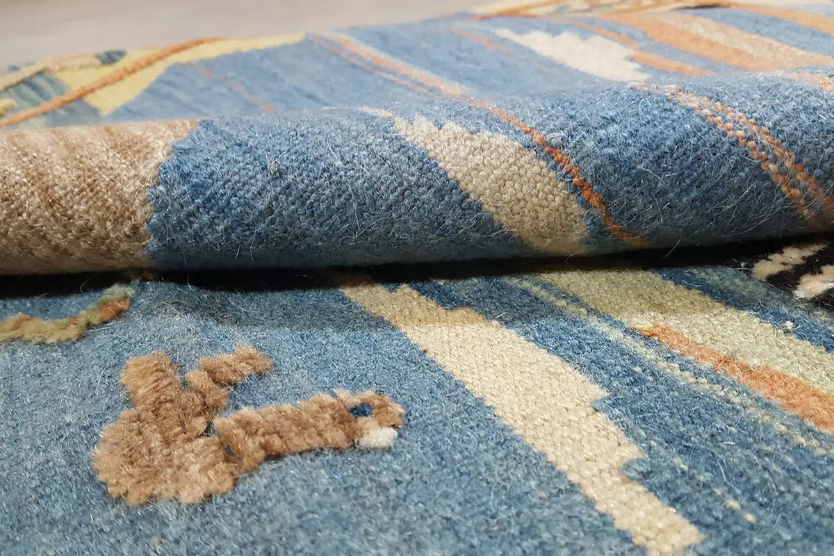 Close-up: blue kilim with beige patterns and a handwoven pile texture