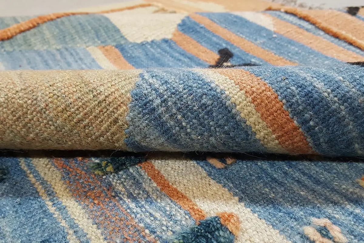 Kilim rug detail: blue, beige and orange stripes in the woven pile
