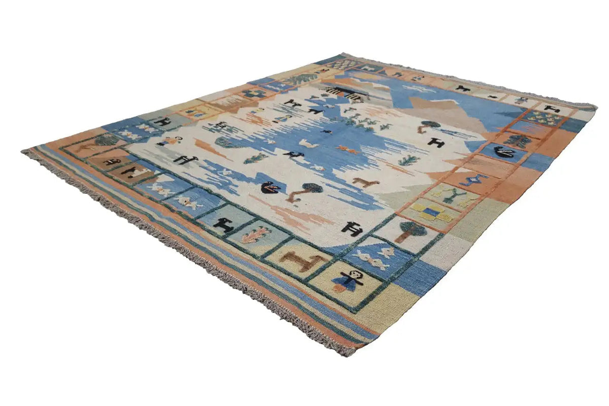 Kilim rug with a geometric pattern in blue, beige, and orange, with fringes at the corners