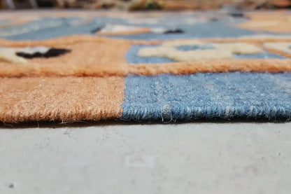 Close-up of the edge of a kilim rug with fringes, blue and beige woven pattern