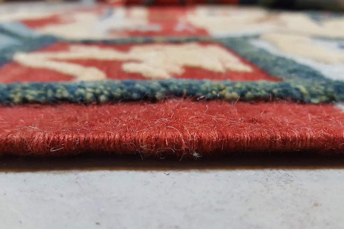 Kilim-Qashqai rug edge view with red pile and dark border frieze