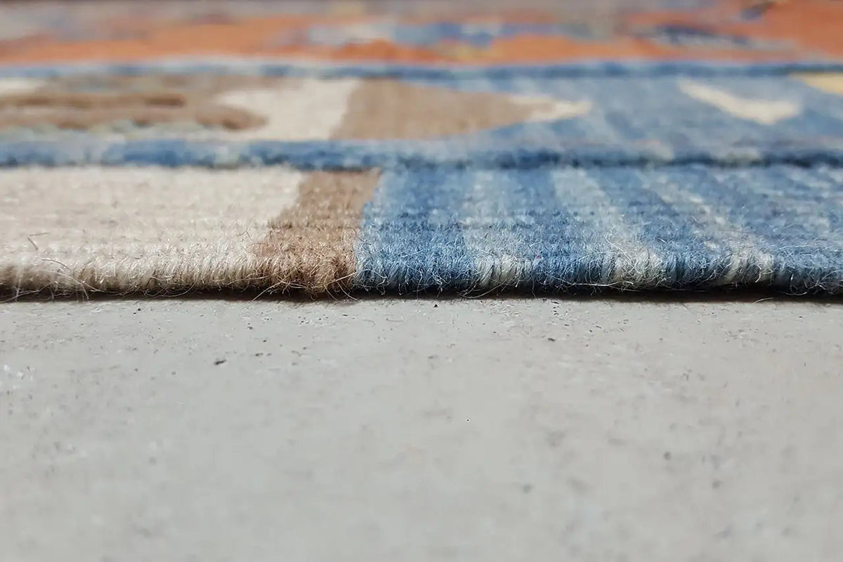 Kilim rug edge view: folded woven structure with a blue stripe and pile at the edge