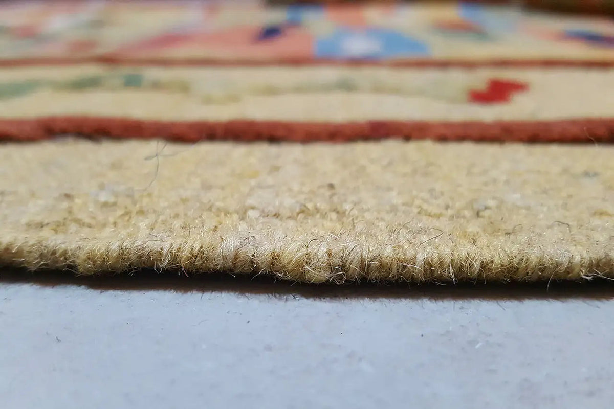 Woven carpet edge with pile and fine fringes, multicolored border pattern