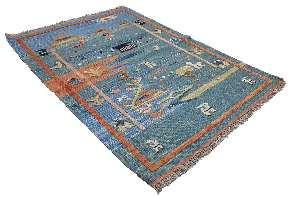 Blue kilim rug spread out, orange border and animal motifs in rows
