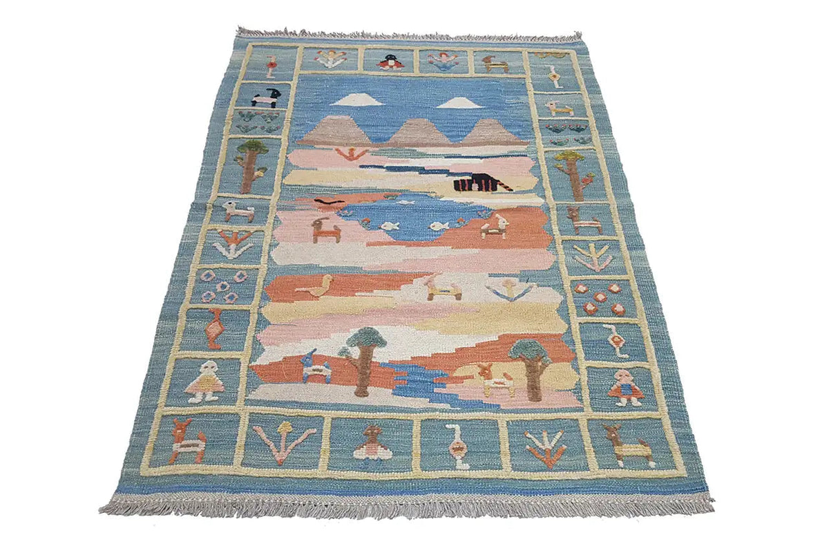 Kilim rug with a blue field, multicolored landscape motifs, and fringes along the edge