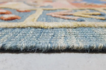 Close-up of the carpet edge: blue woven pattern with a frayed finish