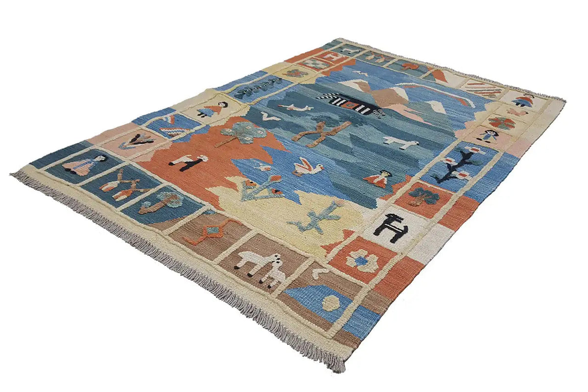 Kilim rug at a three-quarter angle: blue pattern, beige background, orange elements, fringe