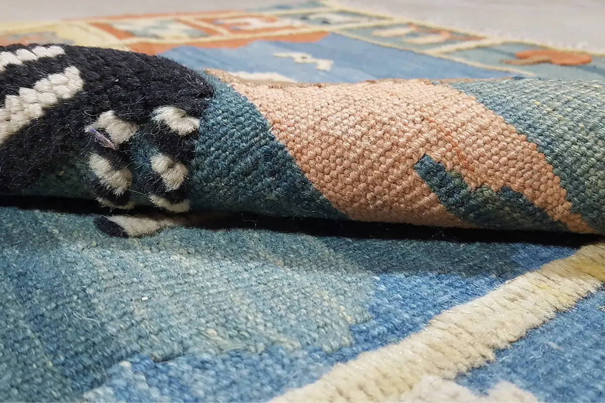 Close-up: woven kilim with blue and beige pile and orange-brown accents