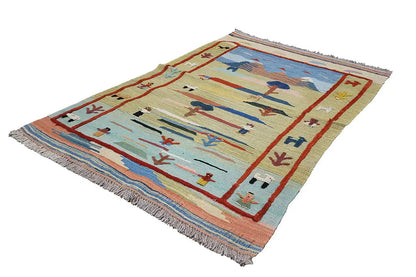 Kilim rug with a landscape motif in light yellow, red, and blue, viewed from the side, with fringes