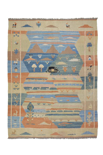 Kilim rug with a blue-beige pattern, geometric motifs, and fringes along the edge.