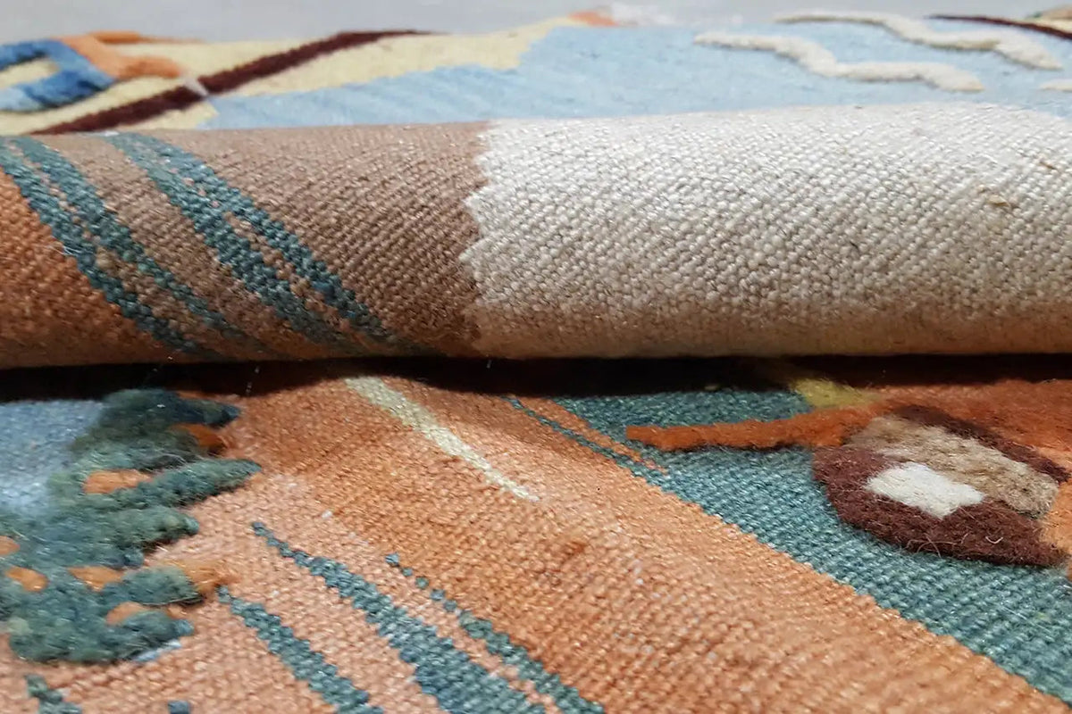 Kilim rug detail: woven texture with multicolored ornamental stripes.