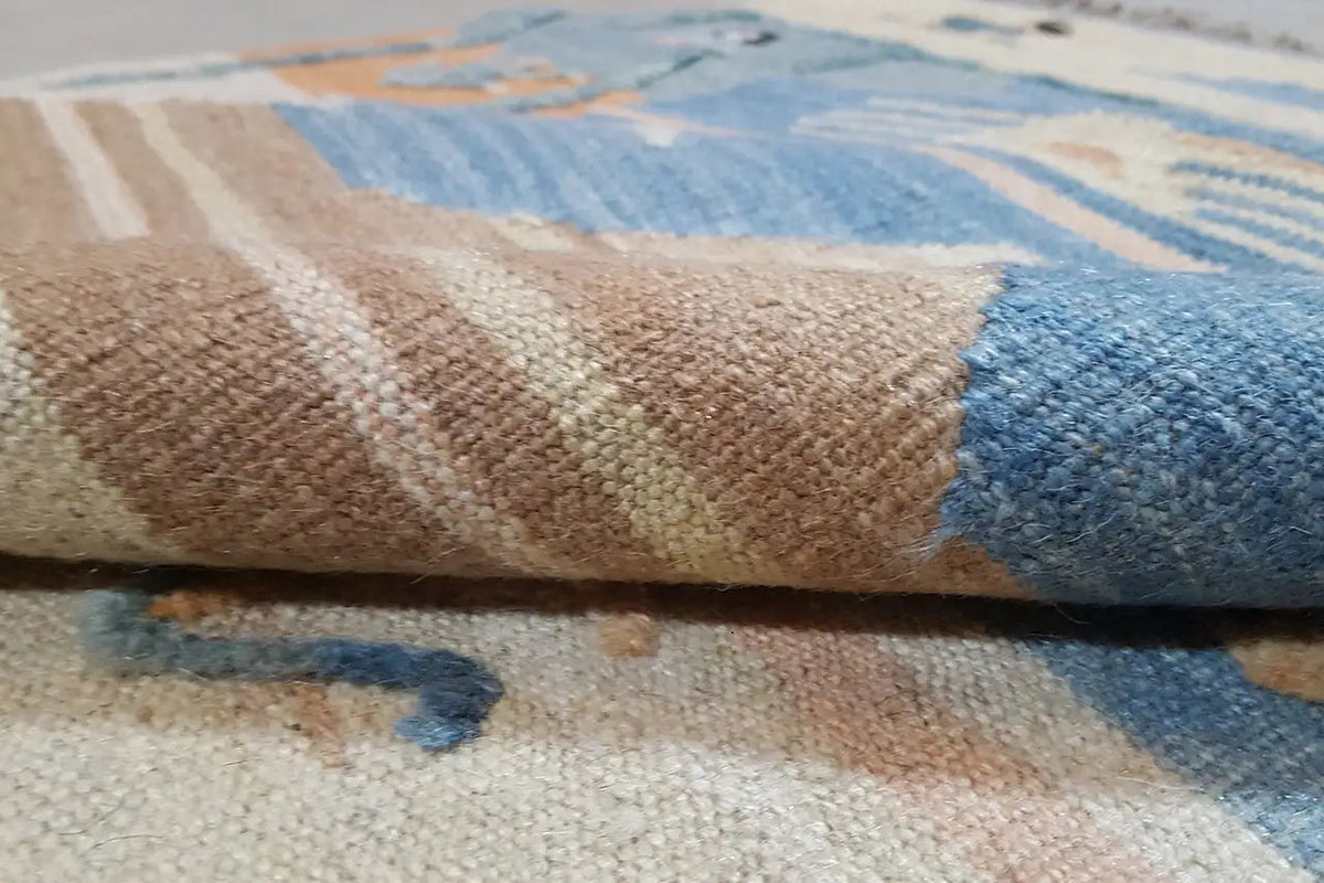Kilim rug close-up: woven texture with a blue and beige pattern
