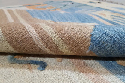 Kilim rug close-up: woven texture with a blue and beige pattern