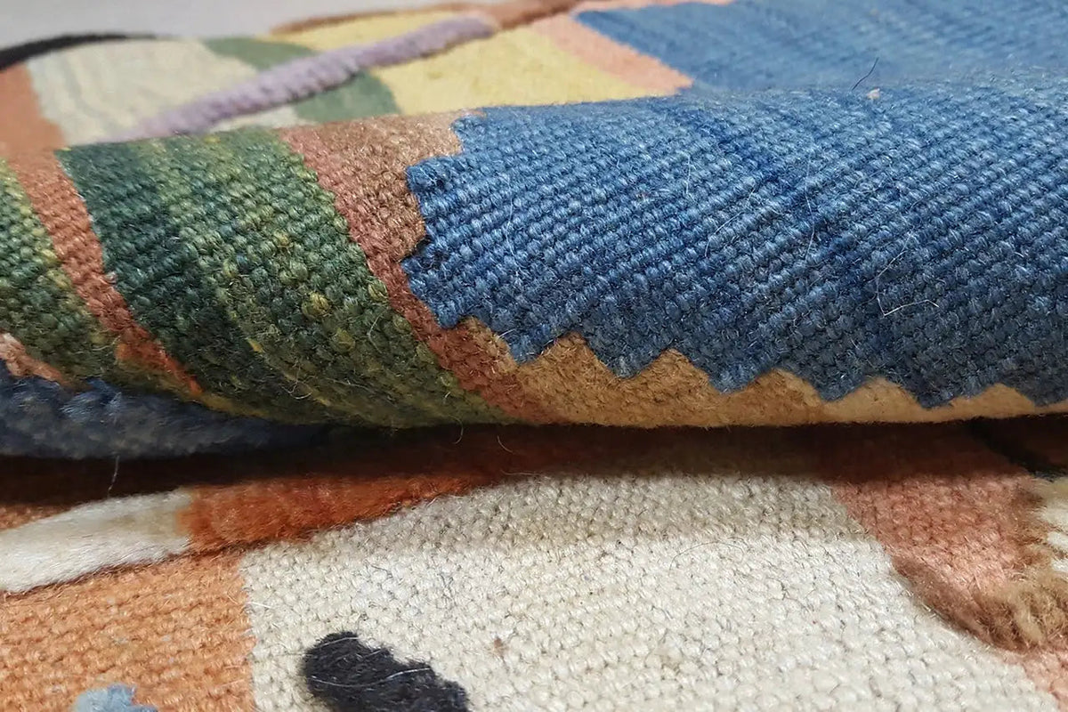 Detailed view: multicolored kilim texture with a blue and green pattern on a beige background