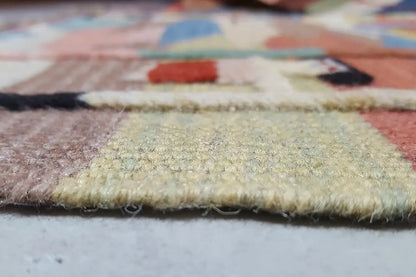 Detail of the carpet edge: pile and weave structure with multicolored patterns, slightly aged