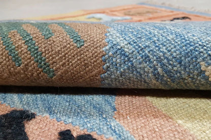Close-up: handwoven kilim rug with blue and beige pile, side edge