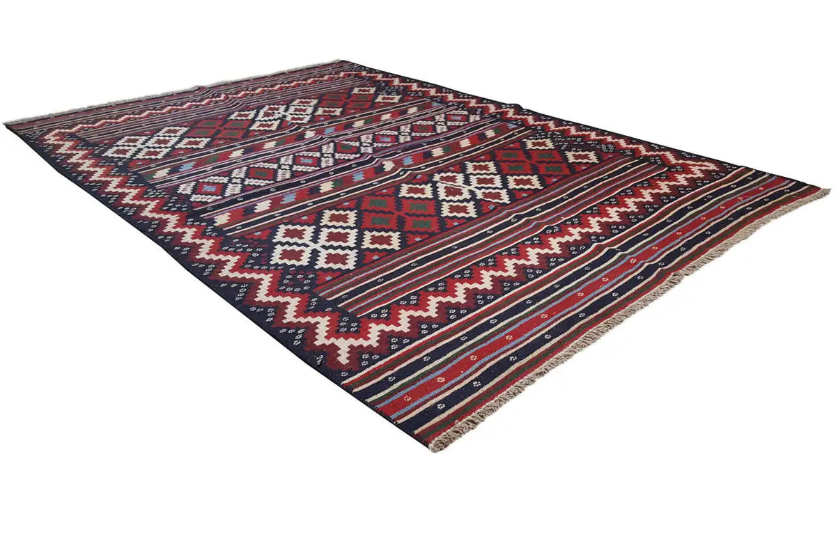 Kilim rug at an angle, black background with red, blue, and white patterns