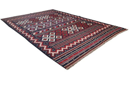 Kilim rug at an angle, black background with red, blue, and white patterns