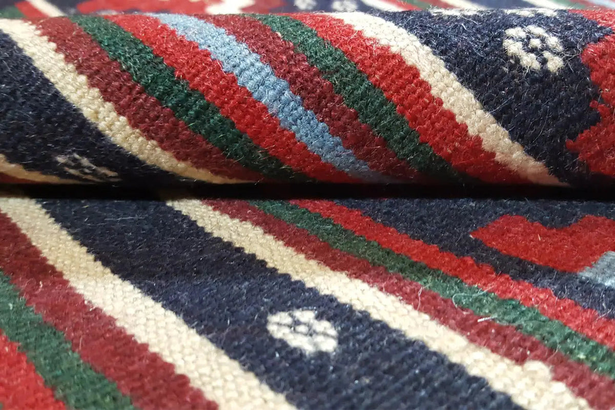 Kilim rug detail: diagonal stripes in red, blue, green, and cream