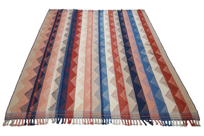 Rectangular jajim rug with zigzag stripes in blue, red, and beige, with fringes.