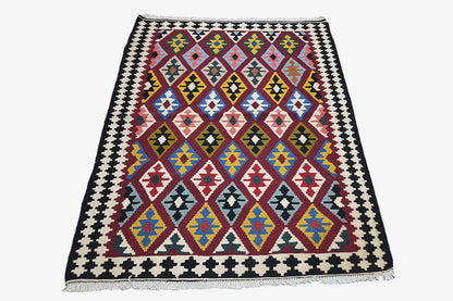 Multicolor kilim rug with a geometric pattern, black border and fringes