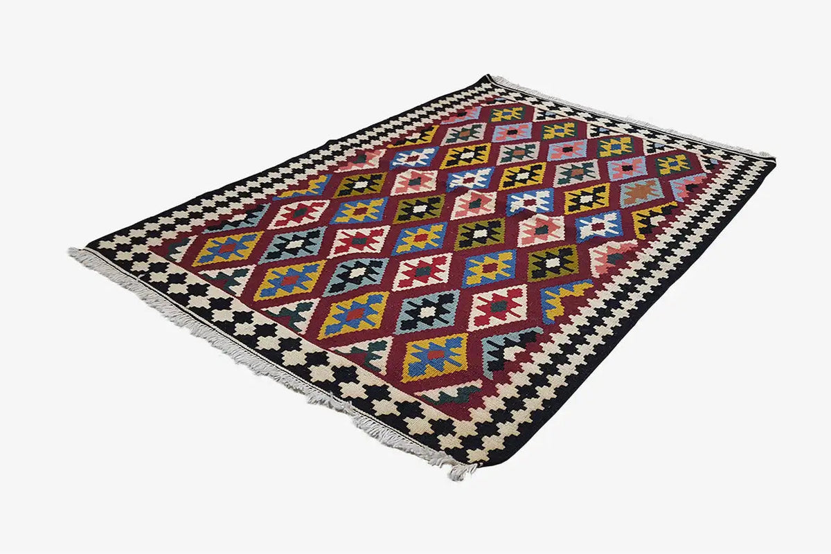 Kilim rug with diamond motifs in blue, red and yellow on a dark background, fringes