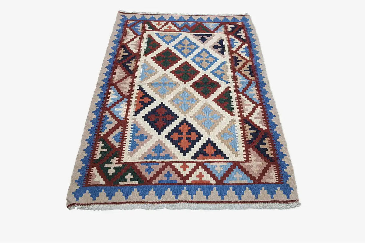 Kilim rug with a multicolored geometric pattern, cream-colored background, and blue border